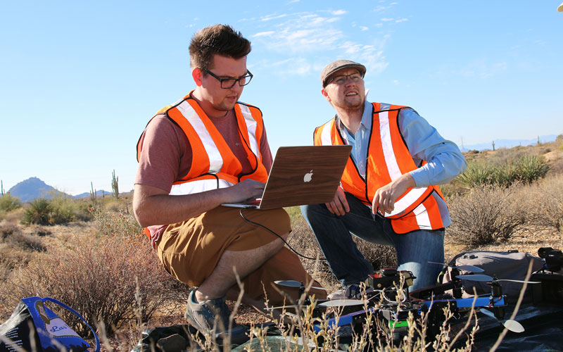 Researchers Ben Stinnett and Brenton Scott pilot the drone over the desert landscape. (Photo by Ty Scholes/Cronkite News)