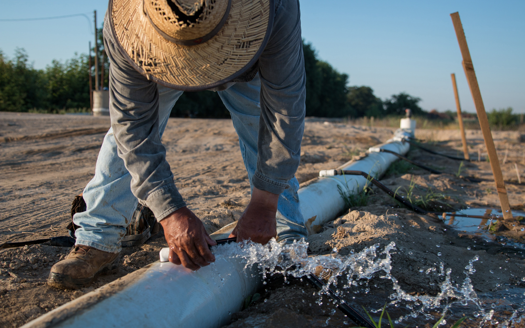 Farmer handling water pipe.