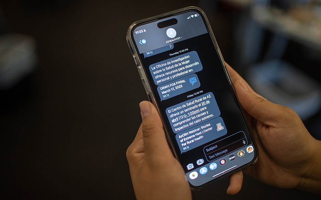 A person holds an iPhone with iMessages on the screen.