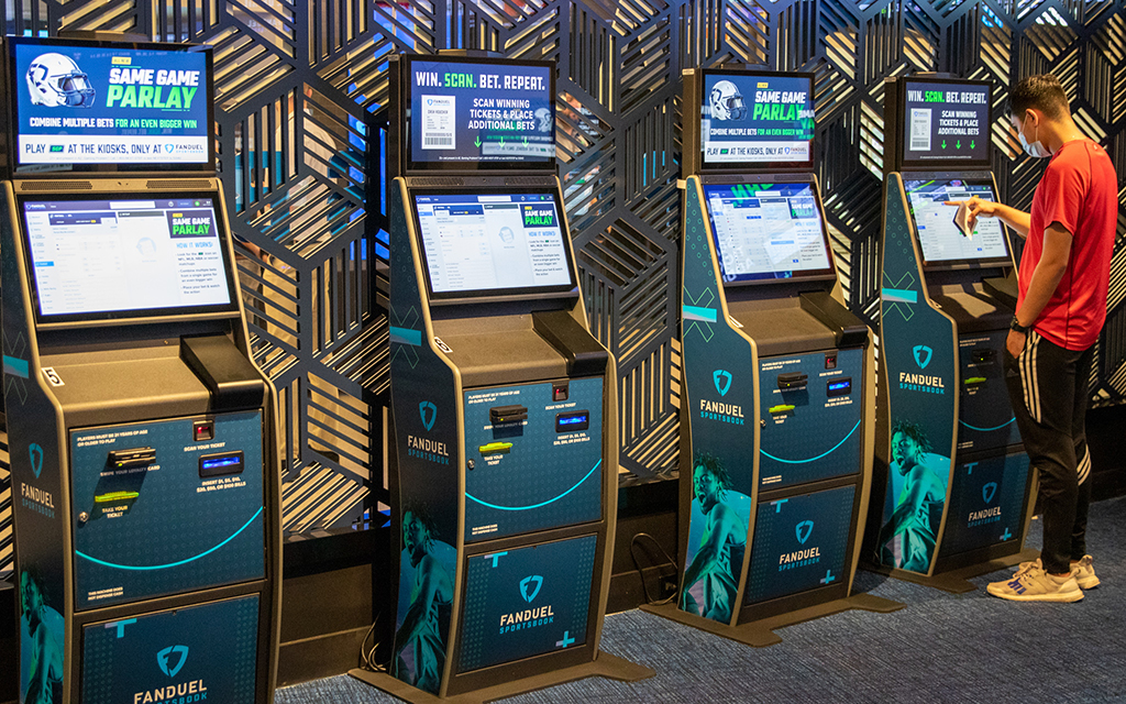 A sports fan checks odds at FanDuel Sportsbook in downtown Phoenix, highlighting the widespread accessibility of legal sports gambling in the U.S. (File photo by James Franks/Cronkite News)