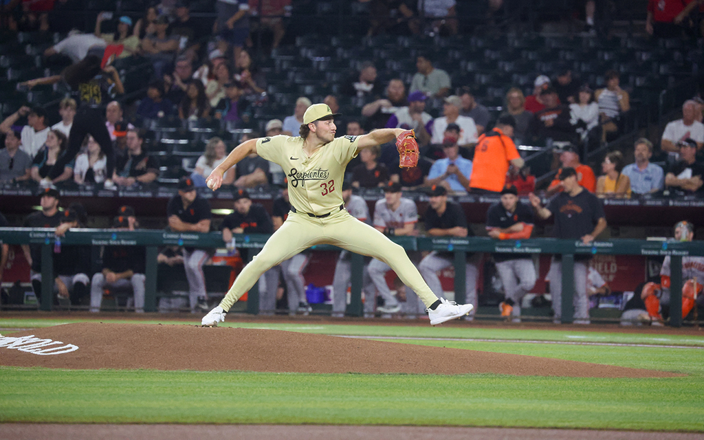 Brandon Pfaadt in the beige Serpientes uniform mid-pitch during a game, with players and spectators in the background.