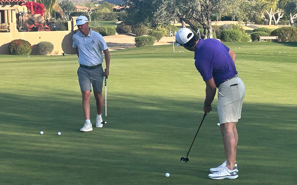 Golfer Will Chandler on a putting green with a tan building and trees in the background at Pinnacle Peak Country Club
