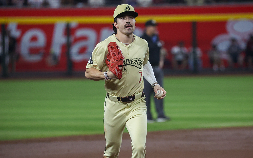 Corbin Carroll in Diamondbacks jersey walks across baseball infield in stadium