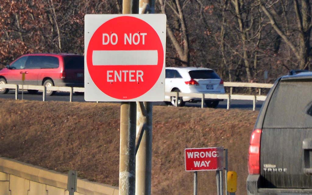 Do Not Enter and Wrong Way signs near a highway.