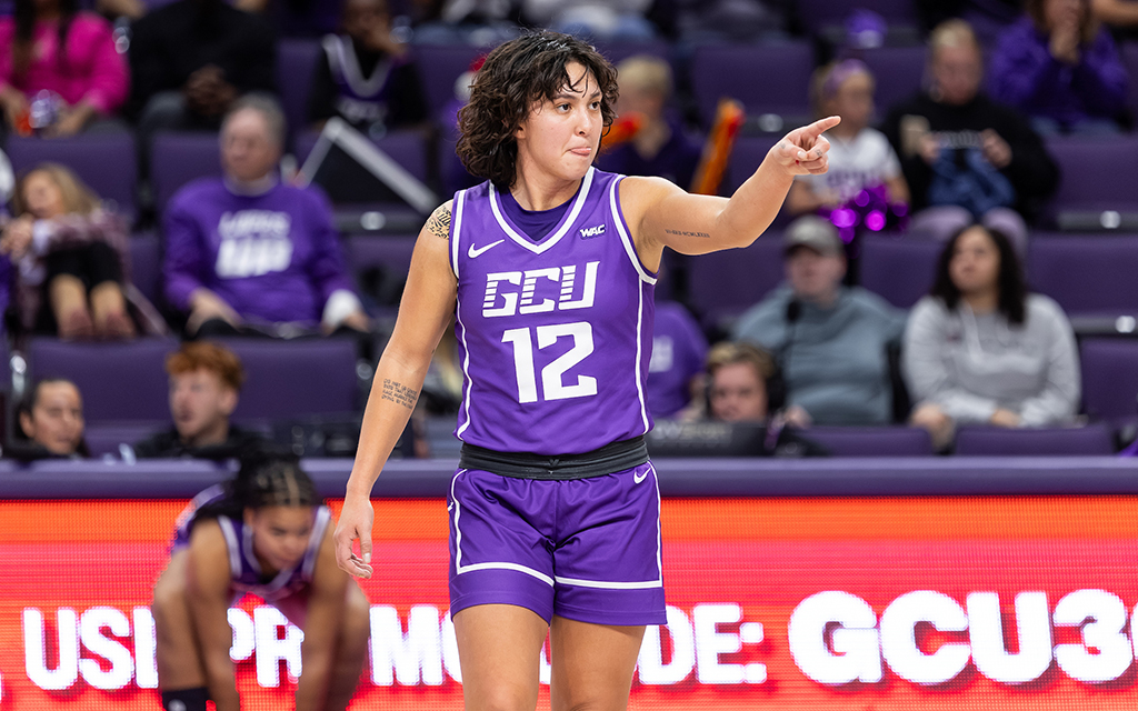 Alyssa Durazo-Frescas in a purple "GCU 12" jersey pointing on the court with spectators in the background in a win against Utah Valley.