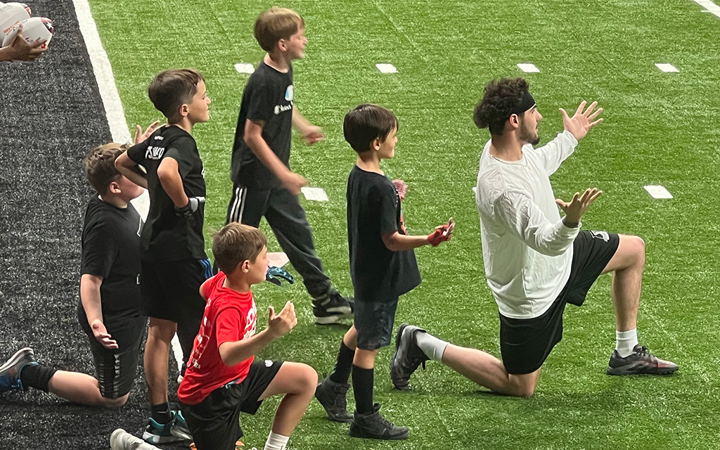 Ron Brown coaches young fans at a youth camp.